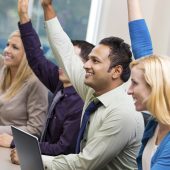 Diverse businesspeople raising hands during meeting or conference