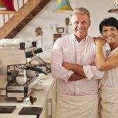 Smiling cafe owners behind counter