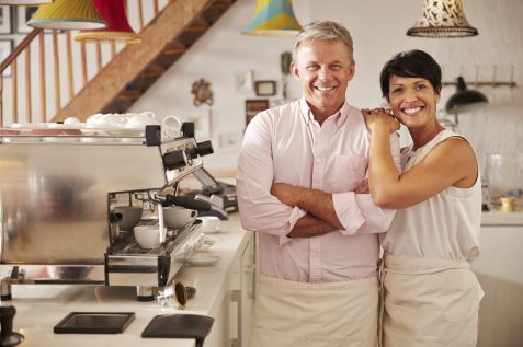 Smiling cafe owners behind counter